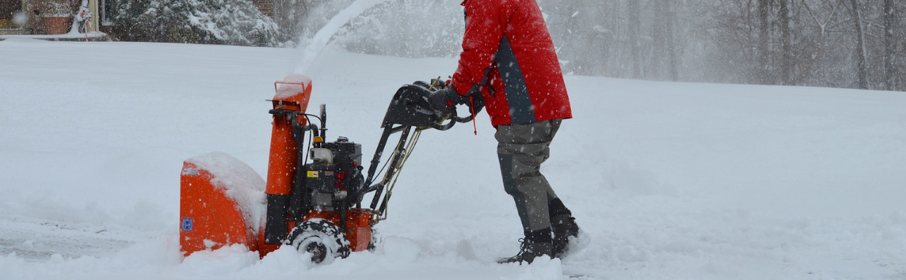 Husqvarna snöslunga körs av man i röd jacka.