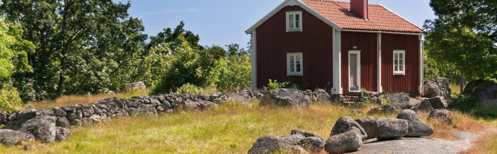 Köpa batteridriven gräsklippare Röd stuga med högt gräs där en slåtterbalk behövs.